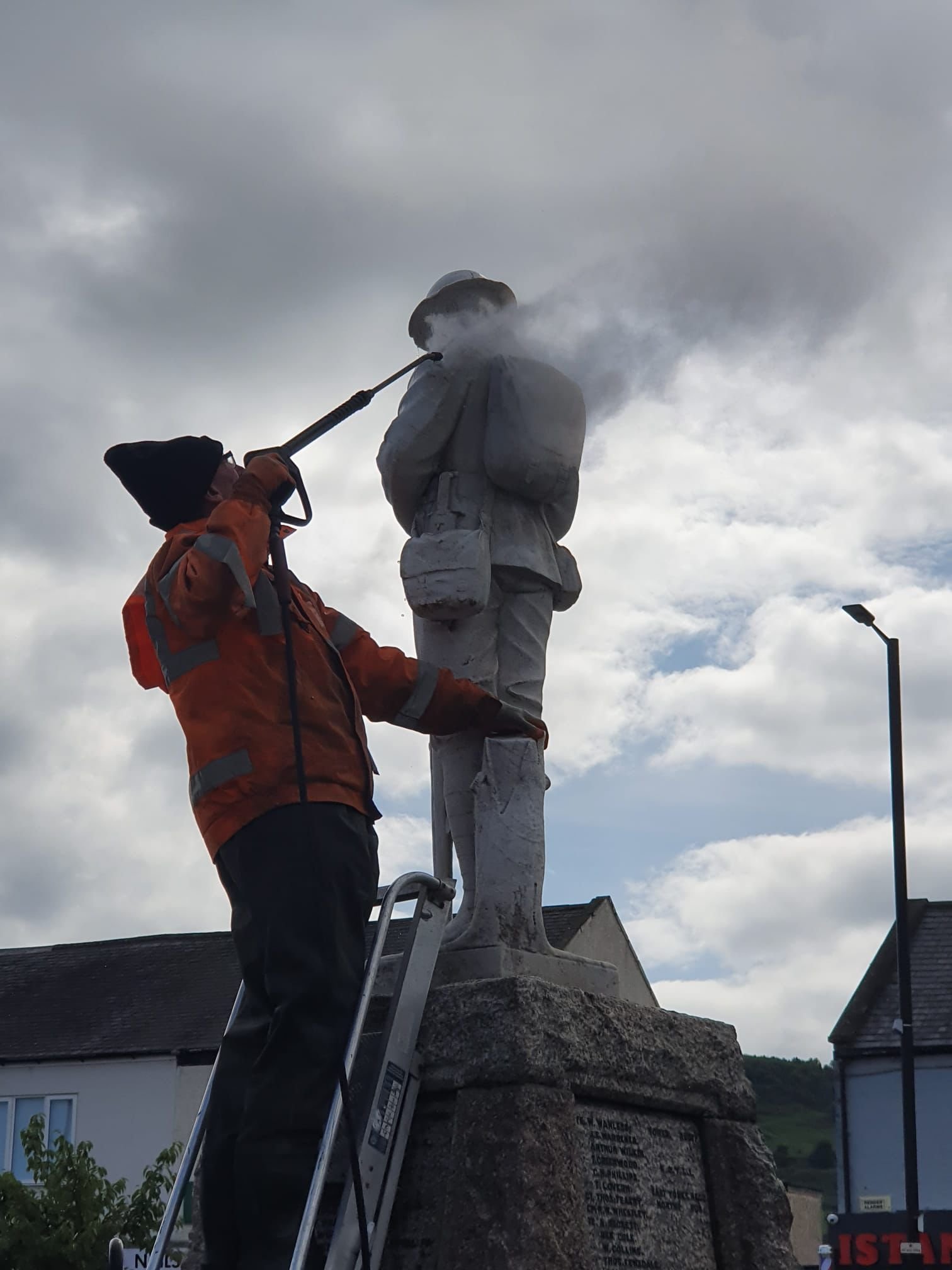 Two people working on the memorial statue